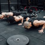 Fitness enthusiasts performing push-ups in a Mexico City gym. Emphasizing teamwork and strength.